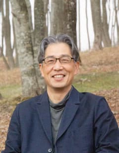 山崎正臣氏のポートレート（林を背景にした屋外写真）